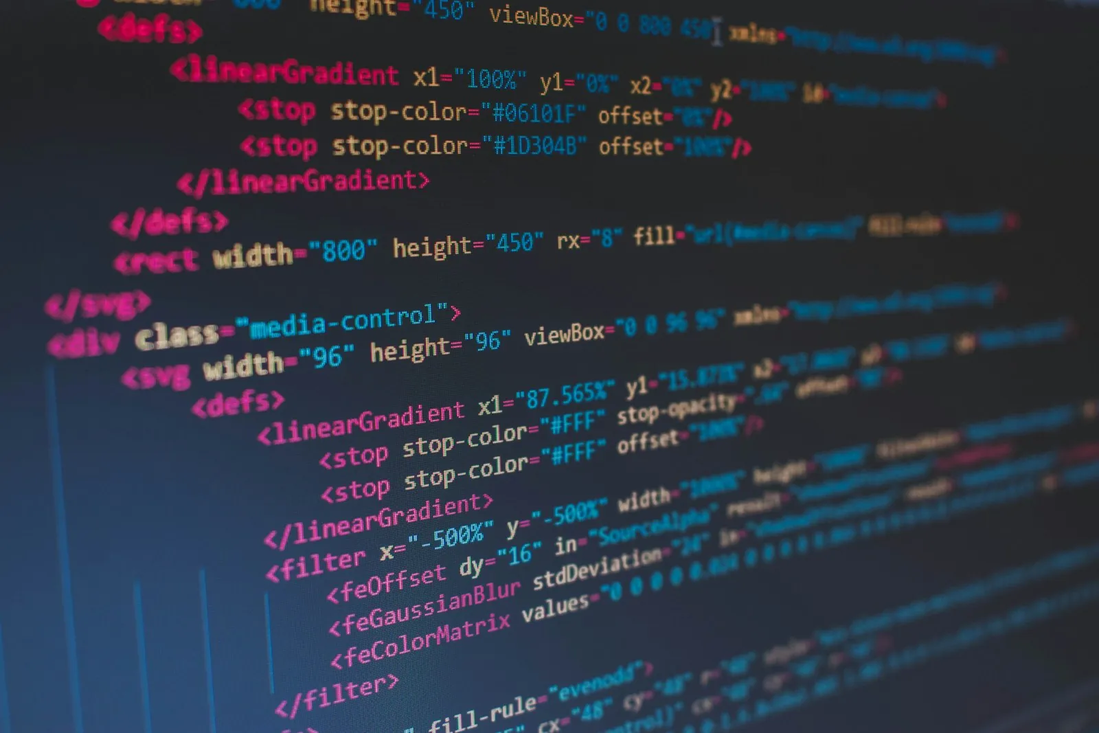 Close-up of colour-highlighted HTML and SVG markup on a dark code editor screen