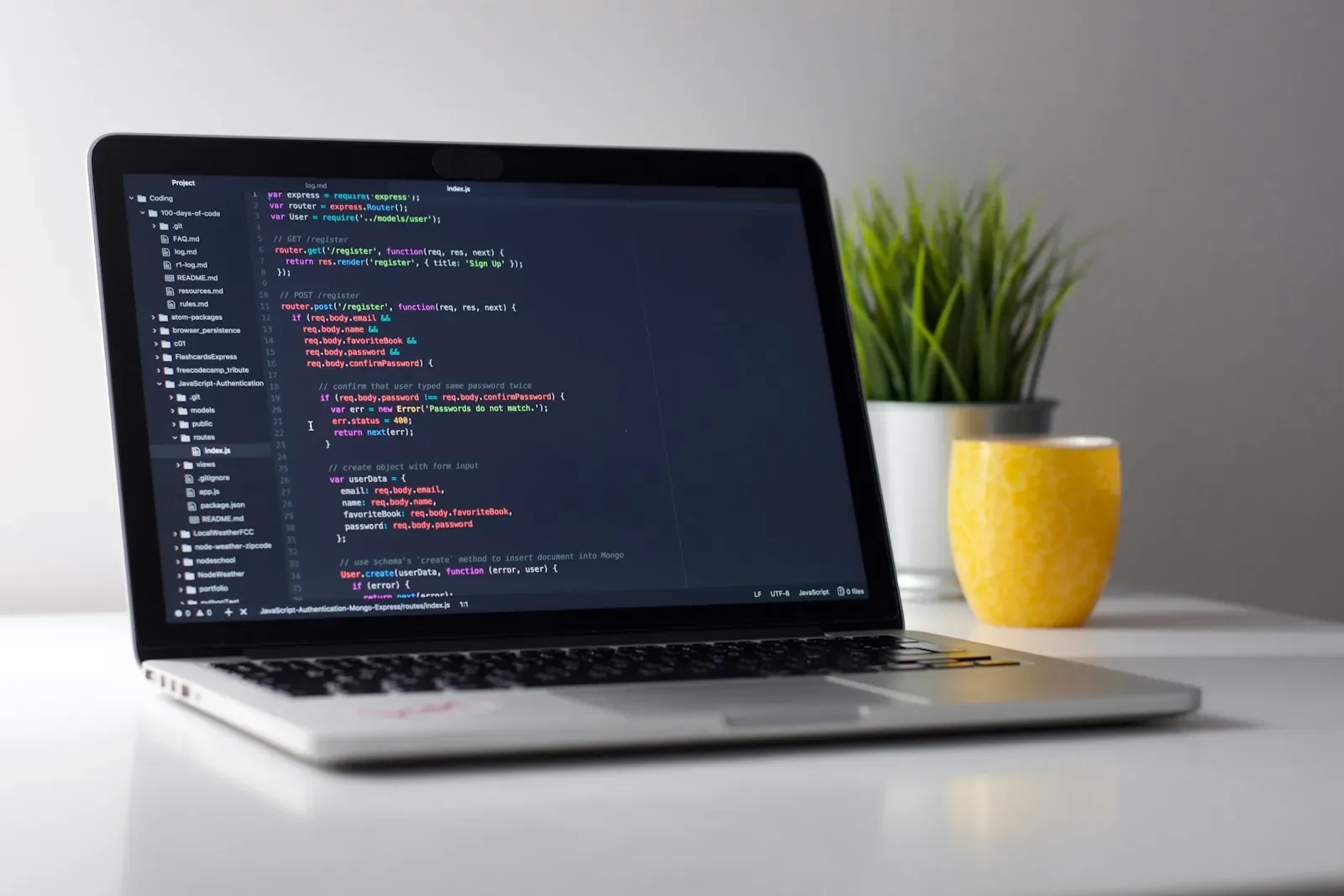 Laptop on a white desk showing website source code – the technical side of an SEO checklist for a new website